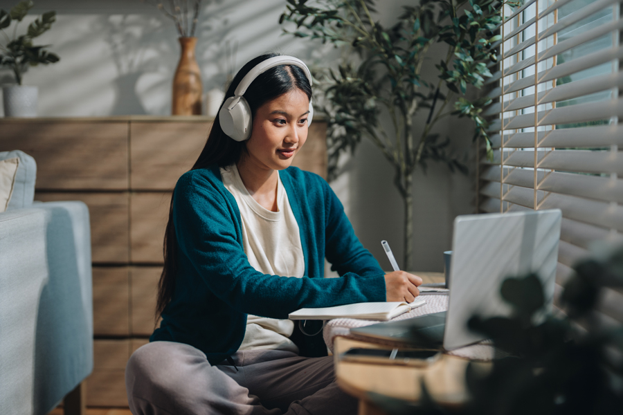 Woman wearing headphones working at a laptop