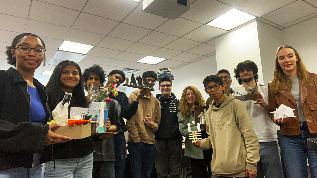 Students with professor holding their projects