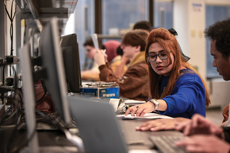 A female student works at a computer.