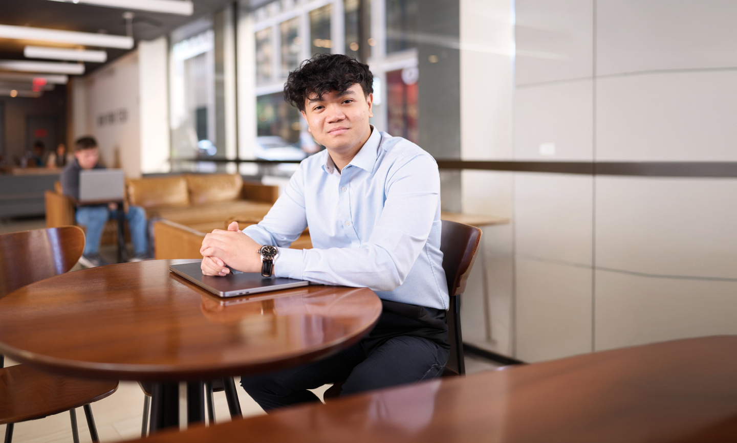A business student works at a table at the New York City campus.
