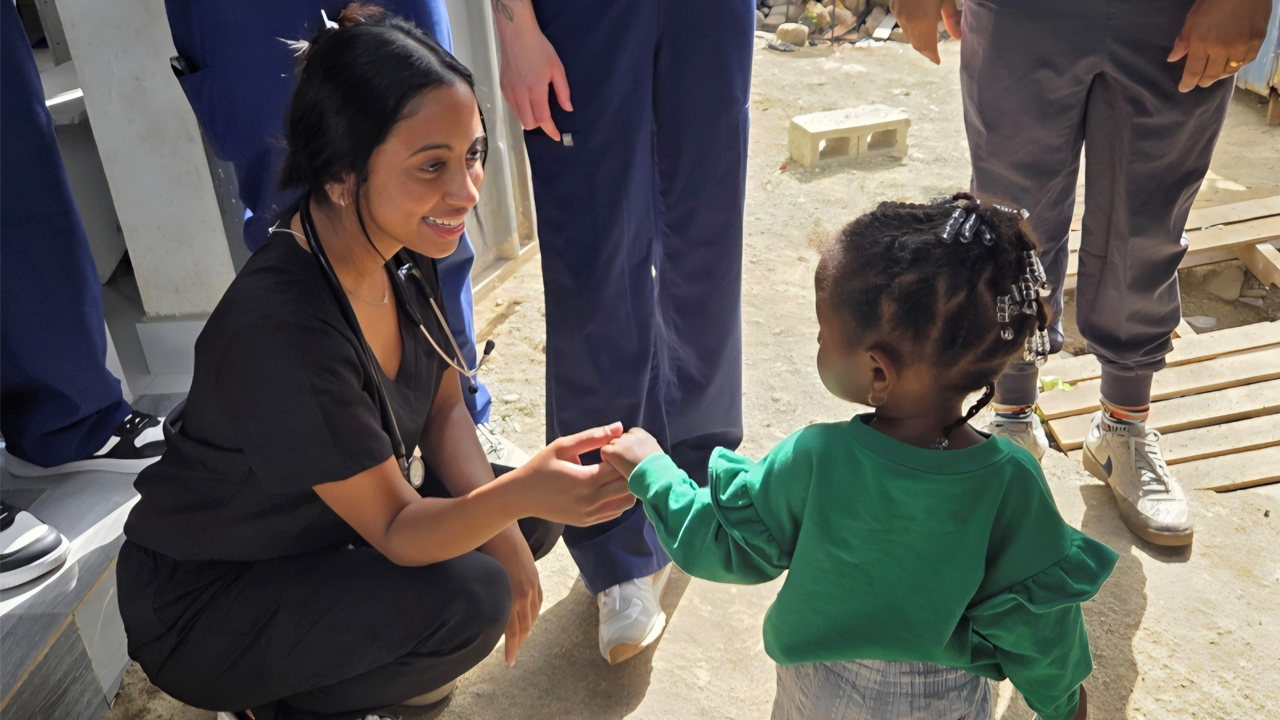 Student holding hands with a child