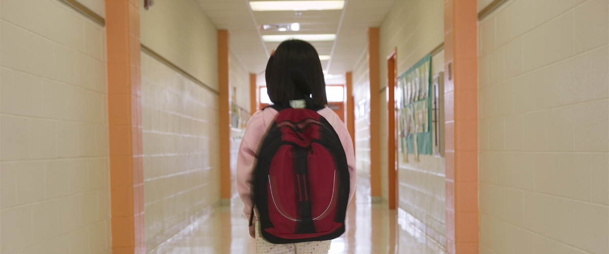 Young student walking down a hallway