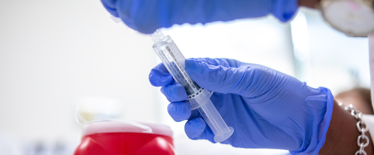 Hand holding vaccine syringe