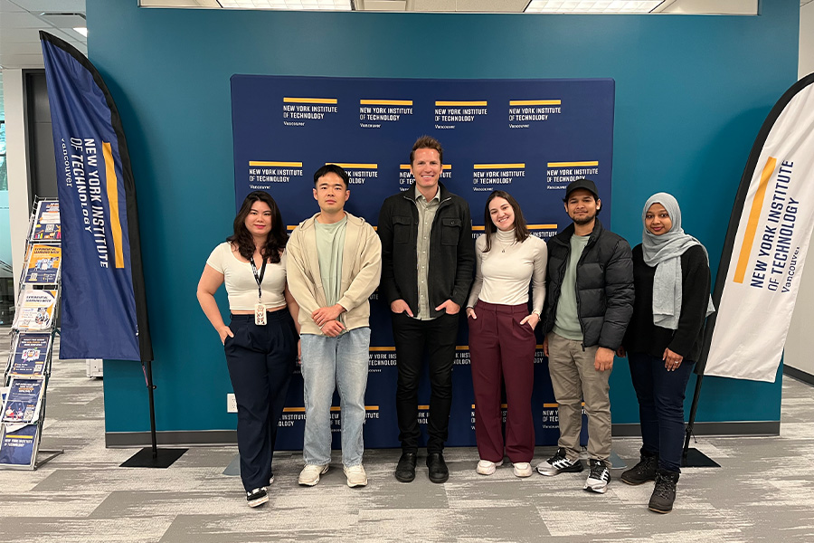 A group of students posing infront of a step and repeat