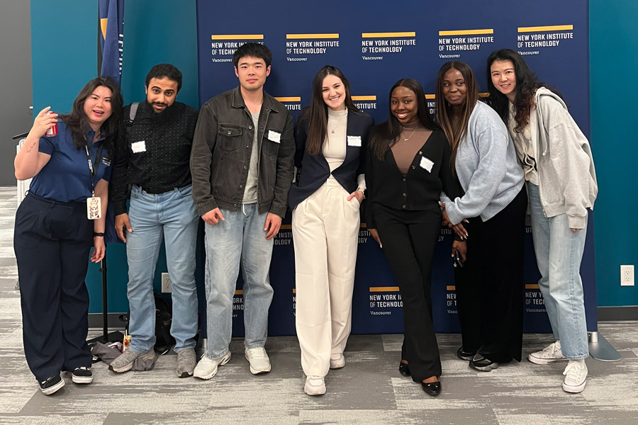 A group of students posing infront of a step and repeat