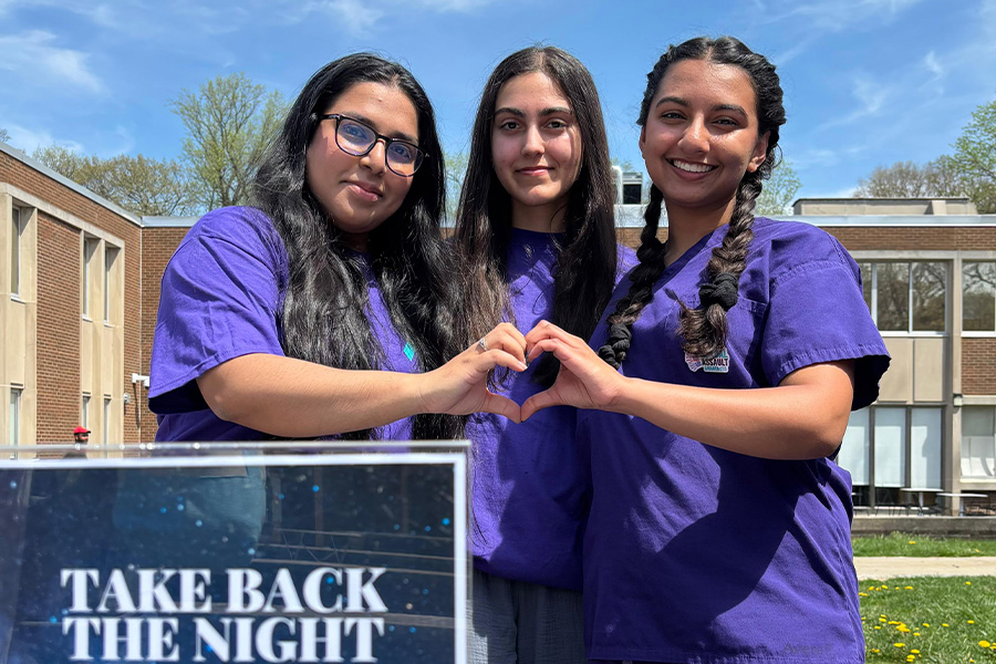 Three students forming a heart with their hands