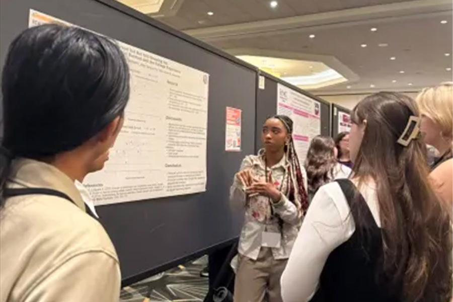 A few people gathered around a poster at an event hall