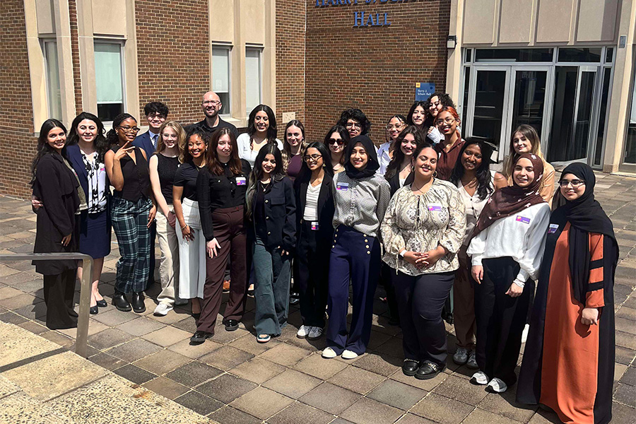 A large group of students posing for a photo outside of a building