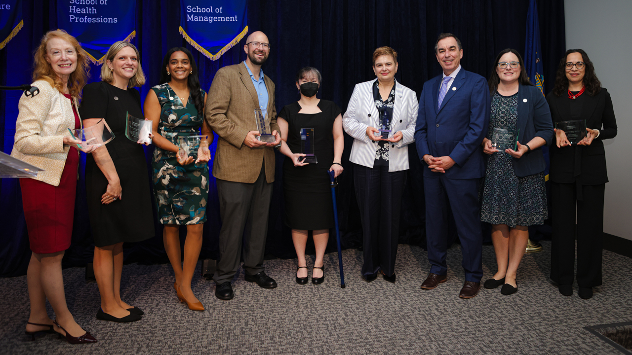 Faculty and staff holding awards