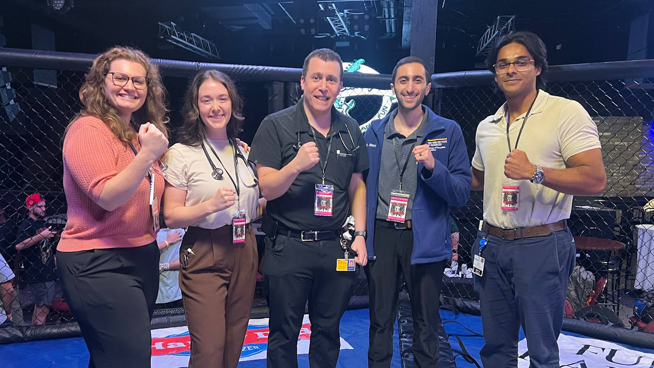 Students and their professor standing in a boxing ring
