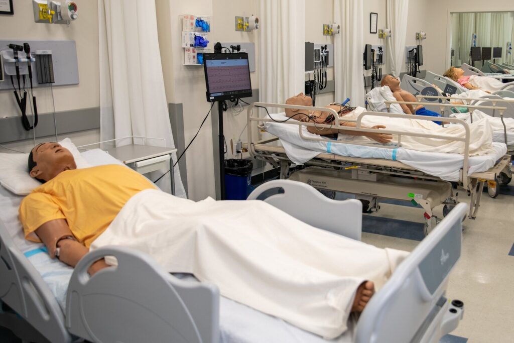 Simulated emergency room with high-fidelity manikins in hospital beds and patient monitors