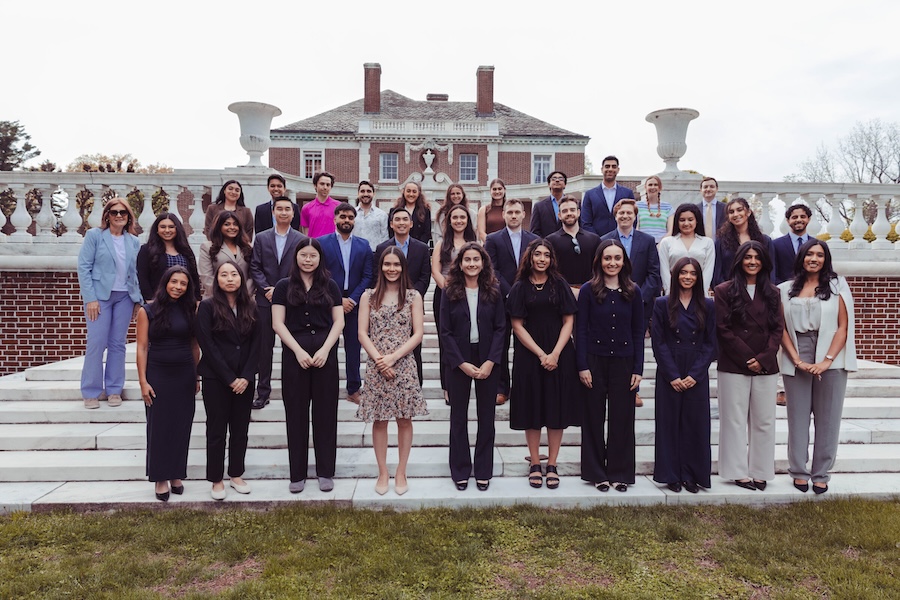 Class of 2026 Gold Humanism Honor Society inductees and faculty posing together on outdoor stone steps