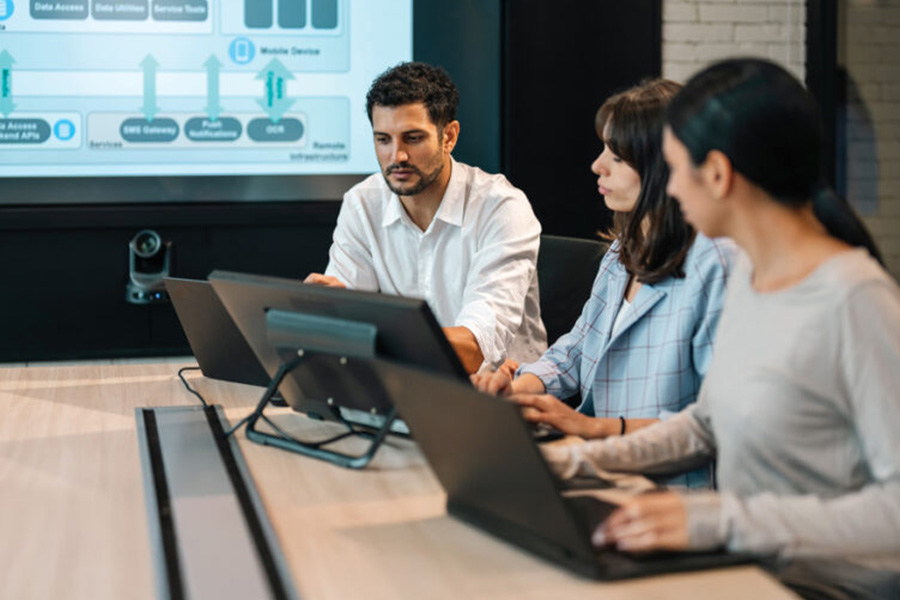 People sitting at a table, using laptops.