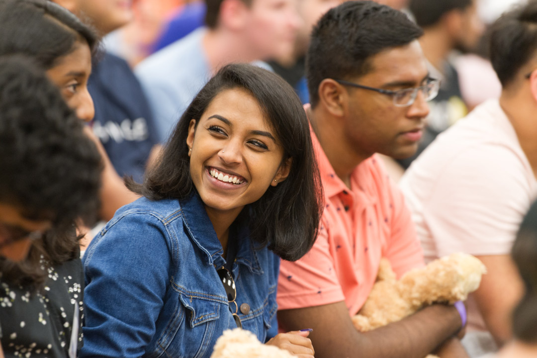 A student is smiling while engaging with a classmate.