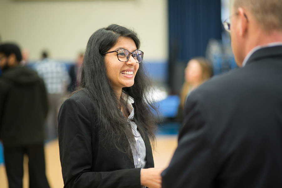 A student at a job fair meeting with potential employers. 