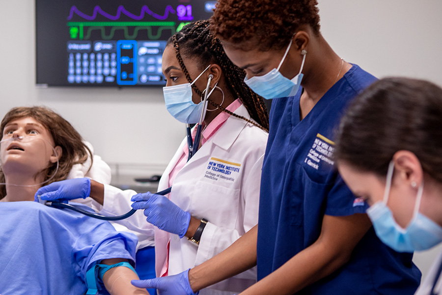 Medical students taking vitals on a dummy