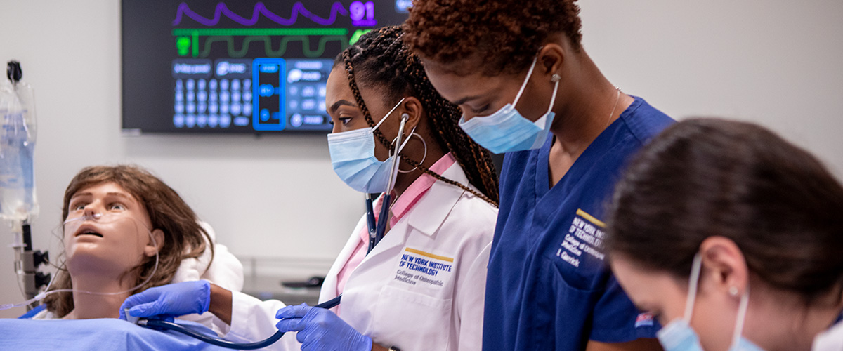 Medical students taking vitals on a dummy