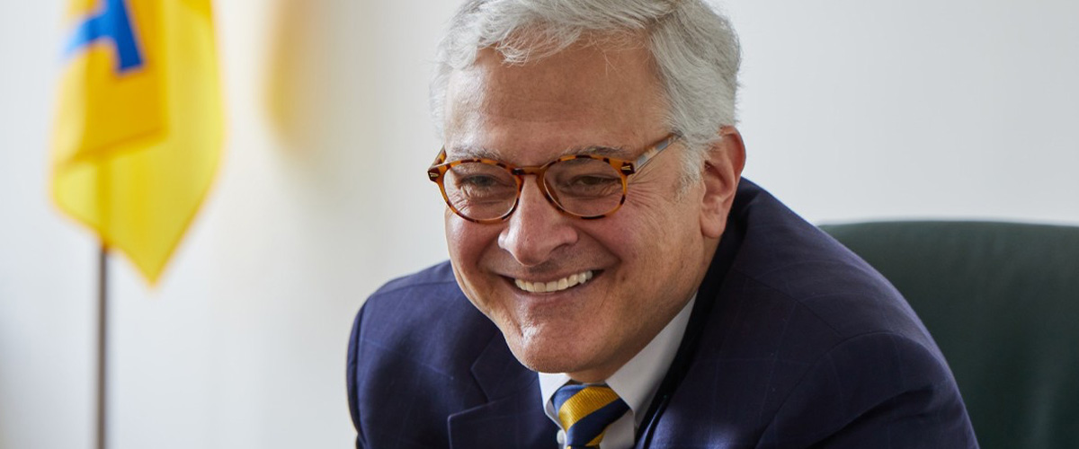 New York Tech President Hank Foley sitting at a desk